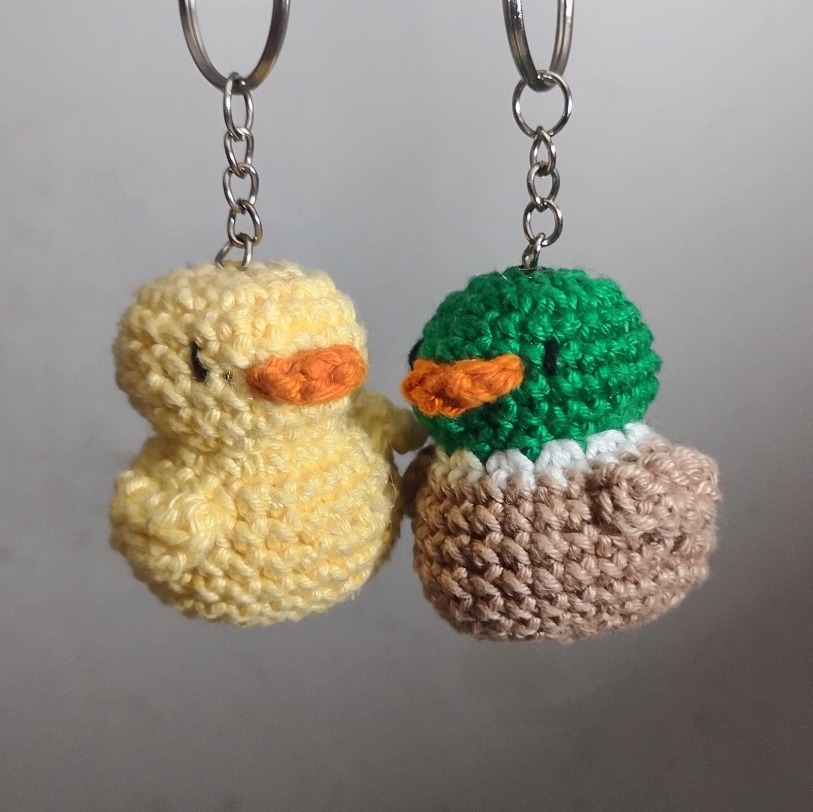 Dois chaveiros de crochê em formato de patinho, amarelo e verde